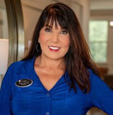 Smiling woman in blue shirt indoors