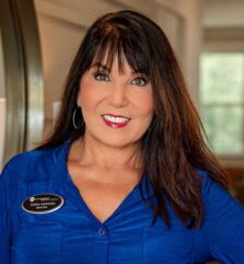 Smiling woman in blue shirt indoors